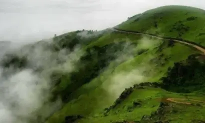 Misty clouds rolling over Mullayanagiri Peak in Chikmagalur during monsoon season