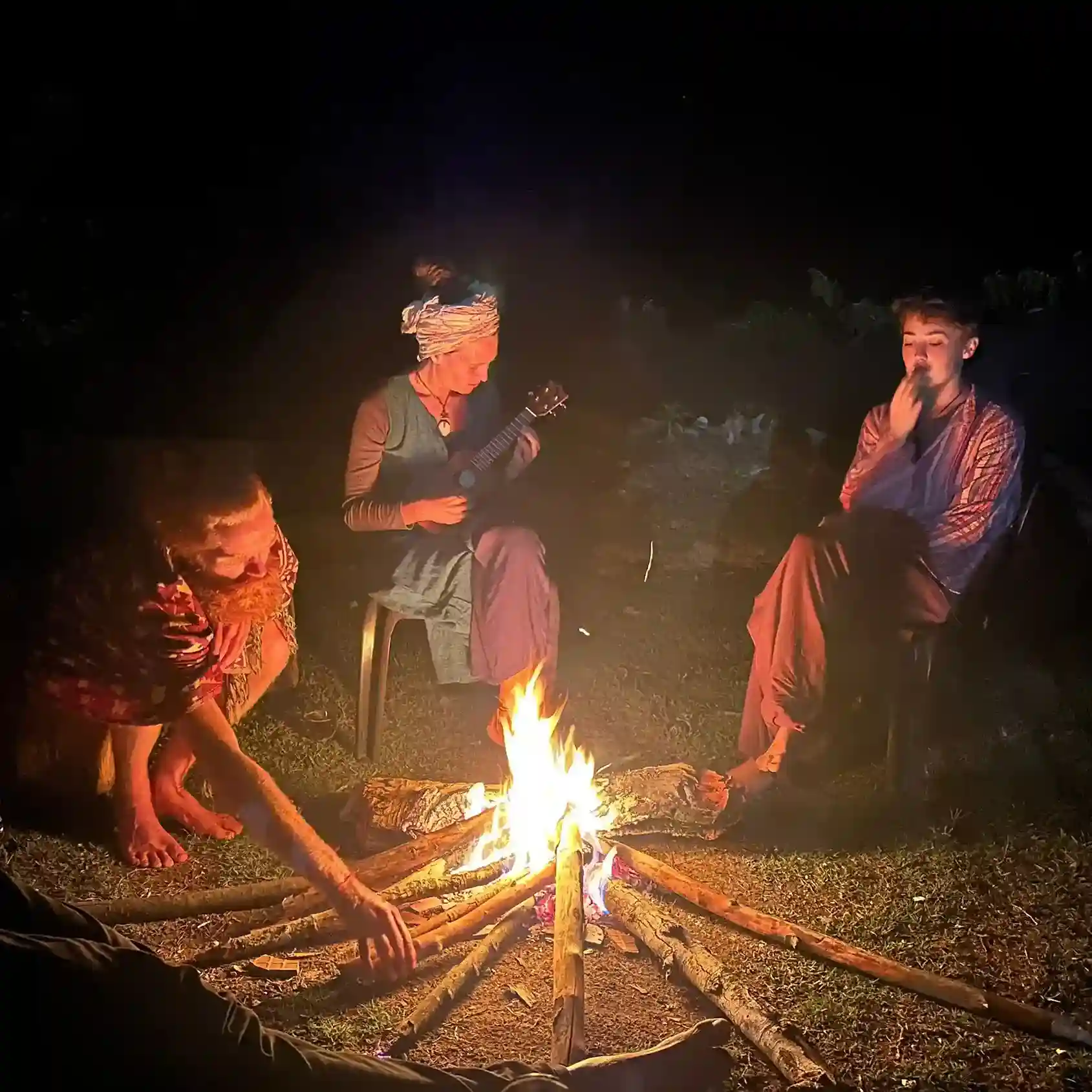 Guests around a bonfire with music at Astagiri homestay.