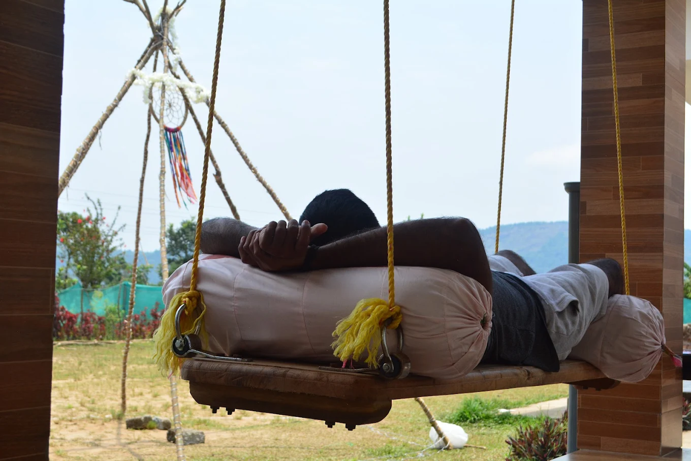 Guest relaxing on a swing with mountain views in Chikmagalur