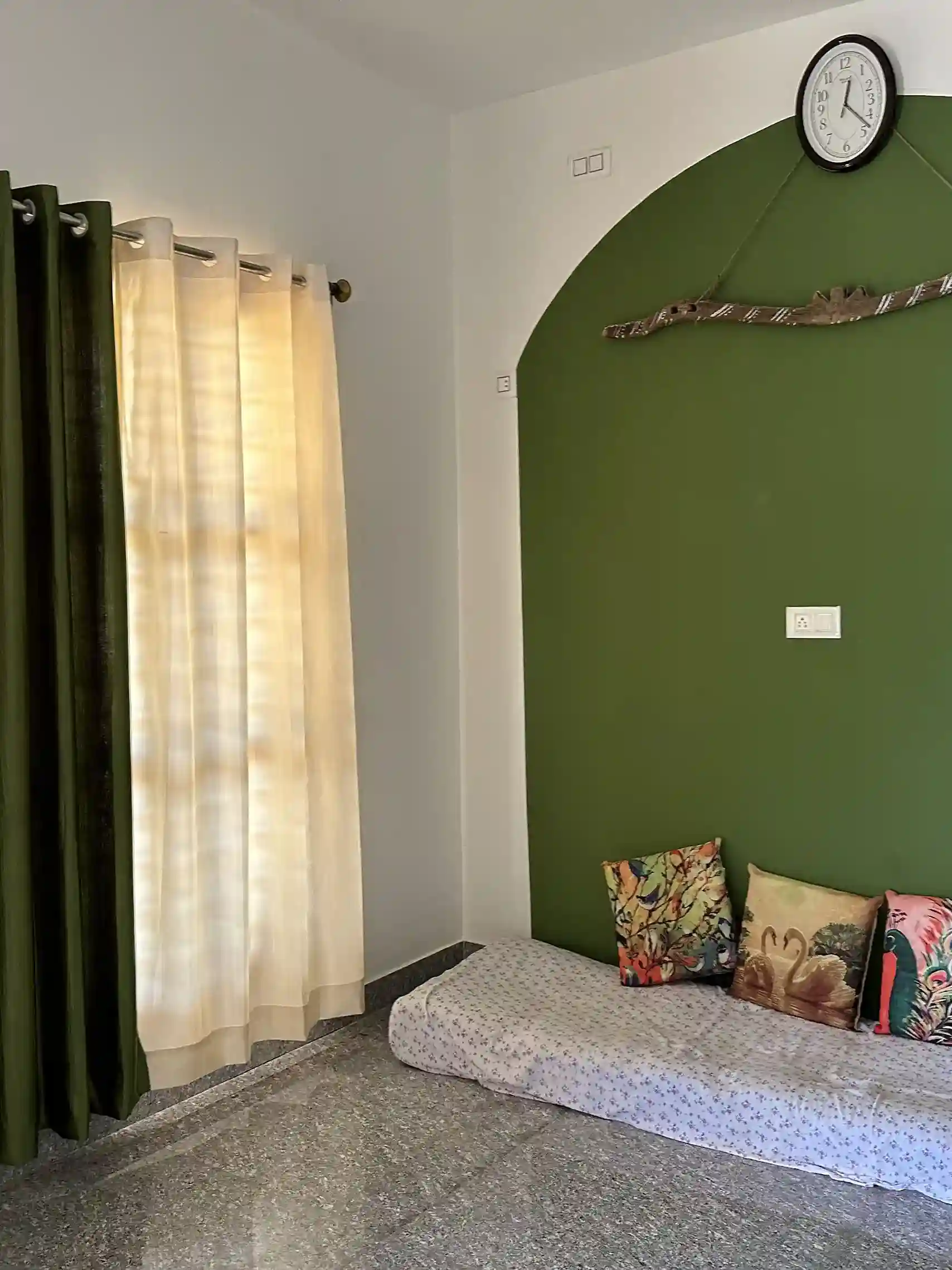 Cozy room with green walls, light curtains, and a window seat.