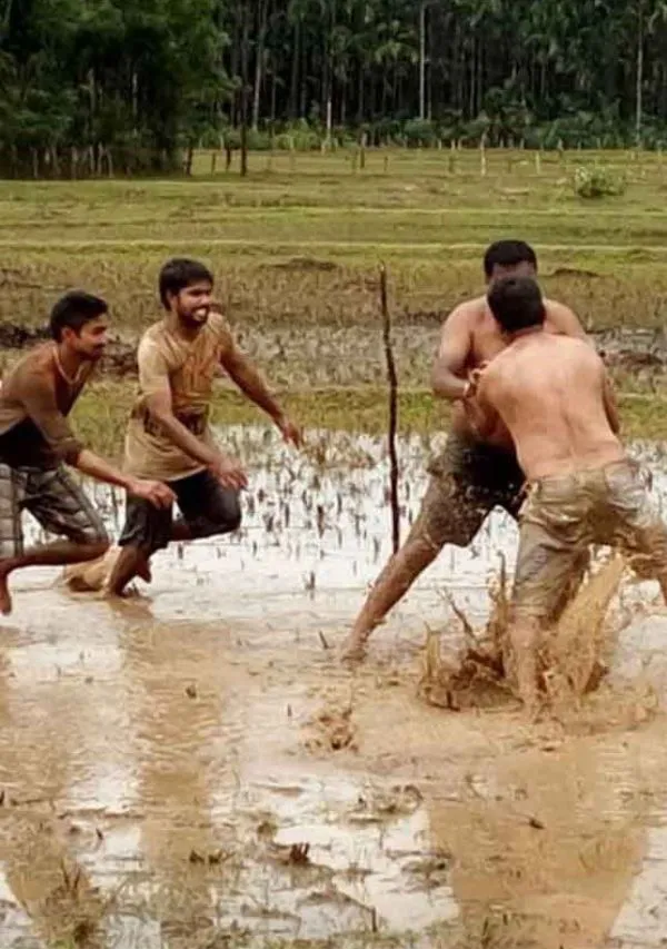 Men playing kabaddi in a muddy field