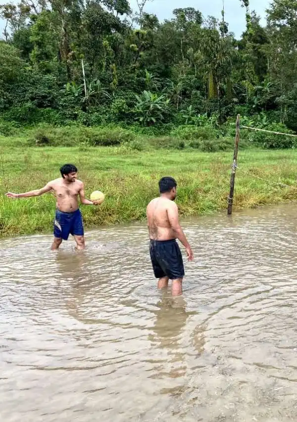 Men playingmud volleyball in a muddy field